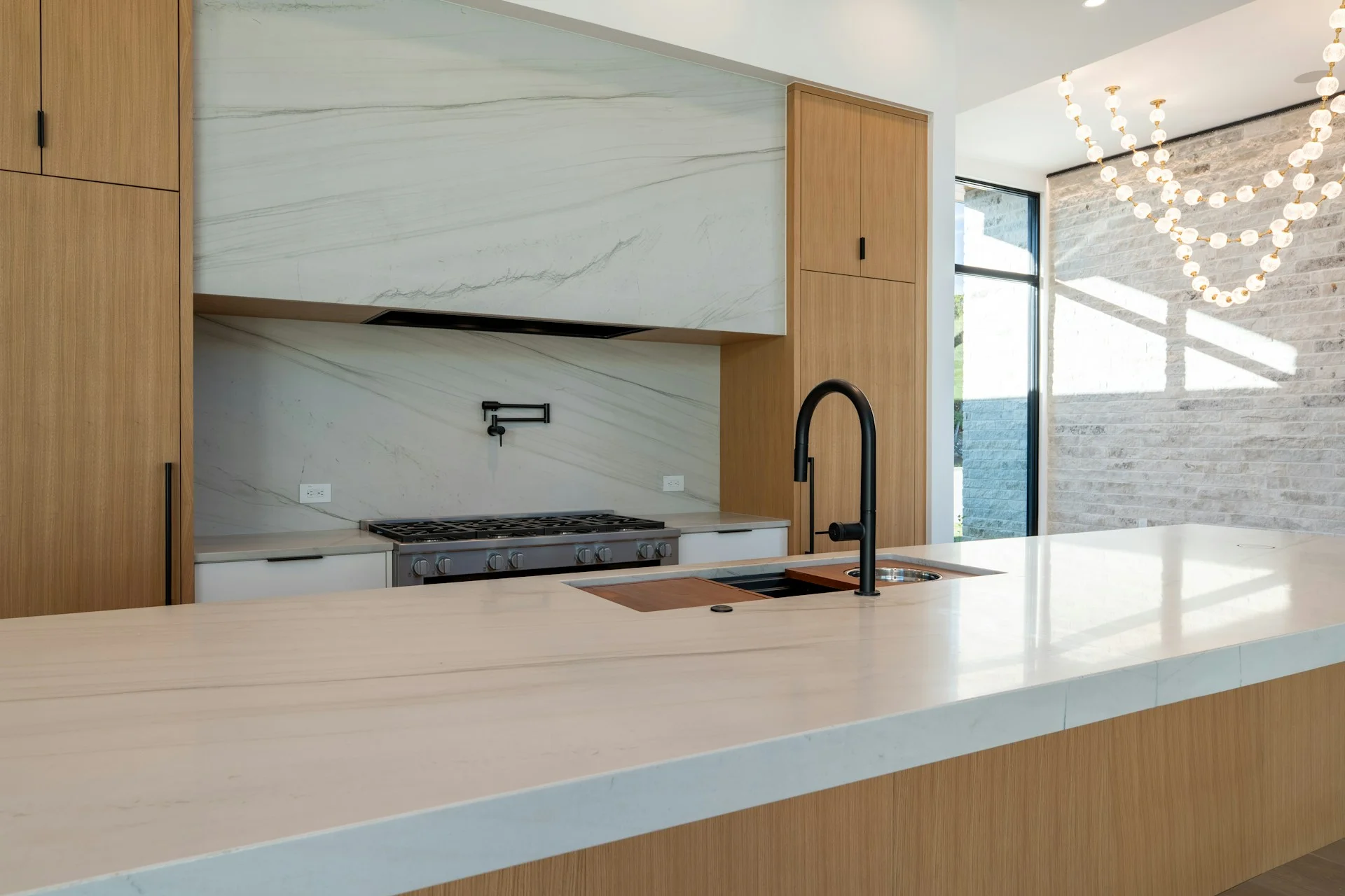 encimeras para la cocina de mármol con muebles de madera y detalles de grifería en negro
