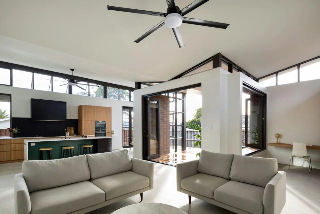 Espacio abierto y luminoso con cocina integrada, salón moderno, techos altos y pavimento continuo de microcemento