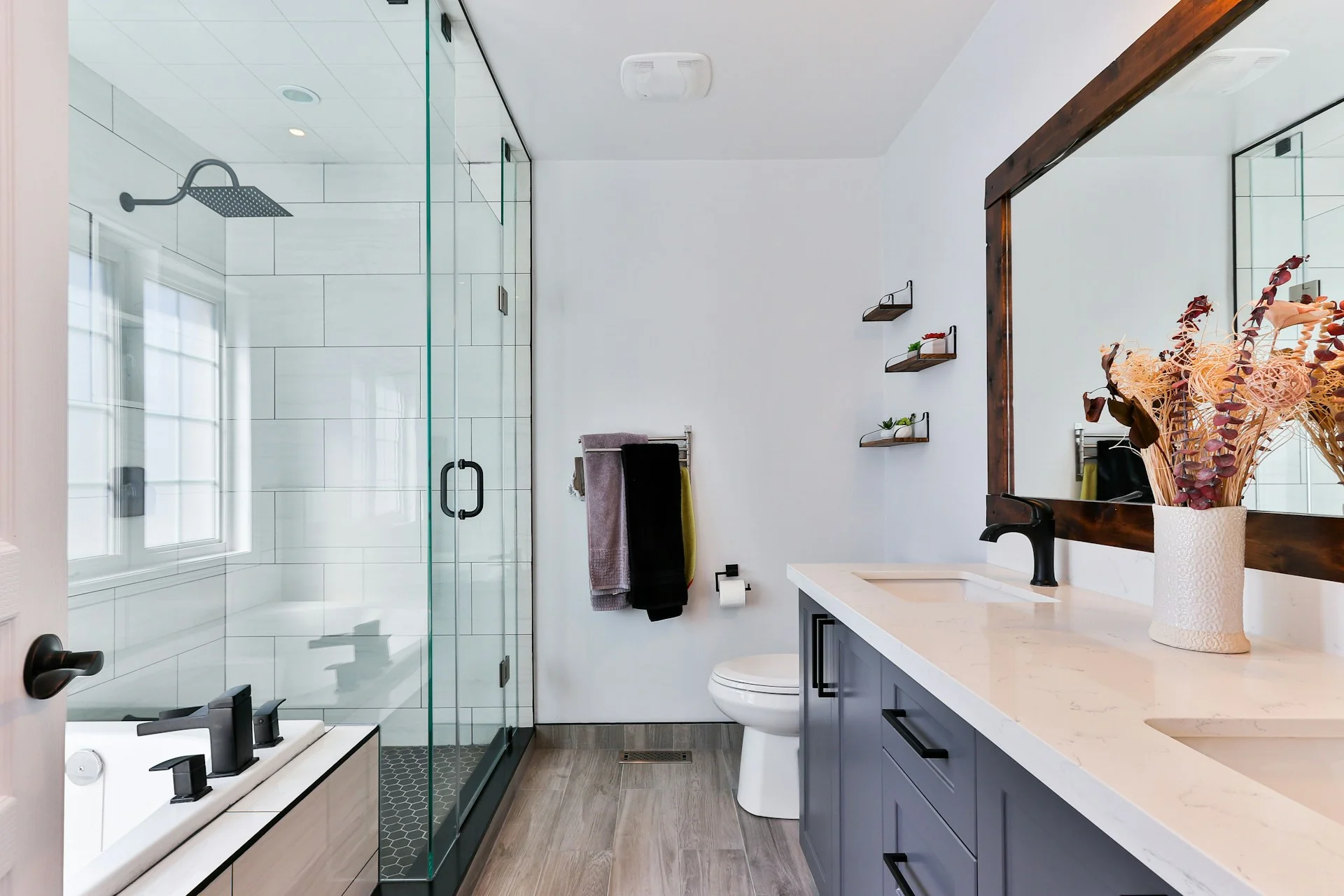 puertas de cristal para baños de cierre completo para la ducha y bañera, azulejos blancos y mueble de lavabo en tonos oscuros