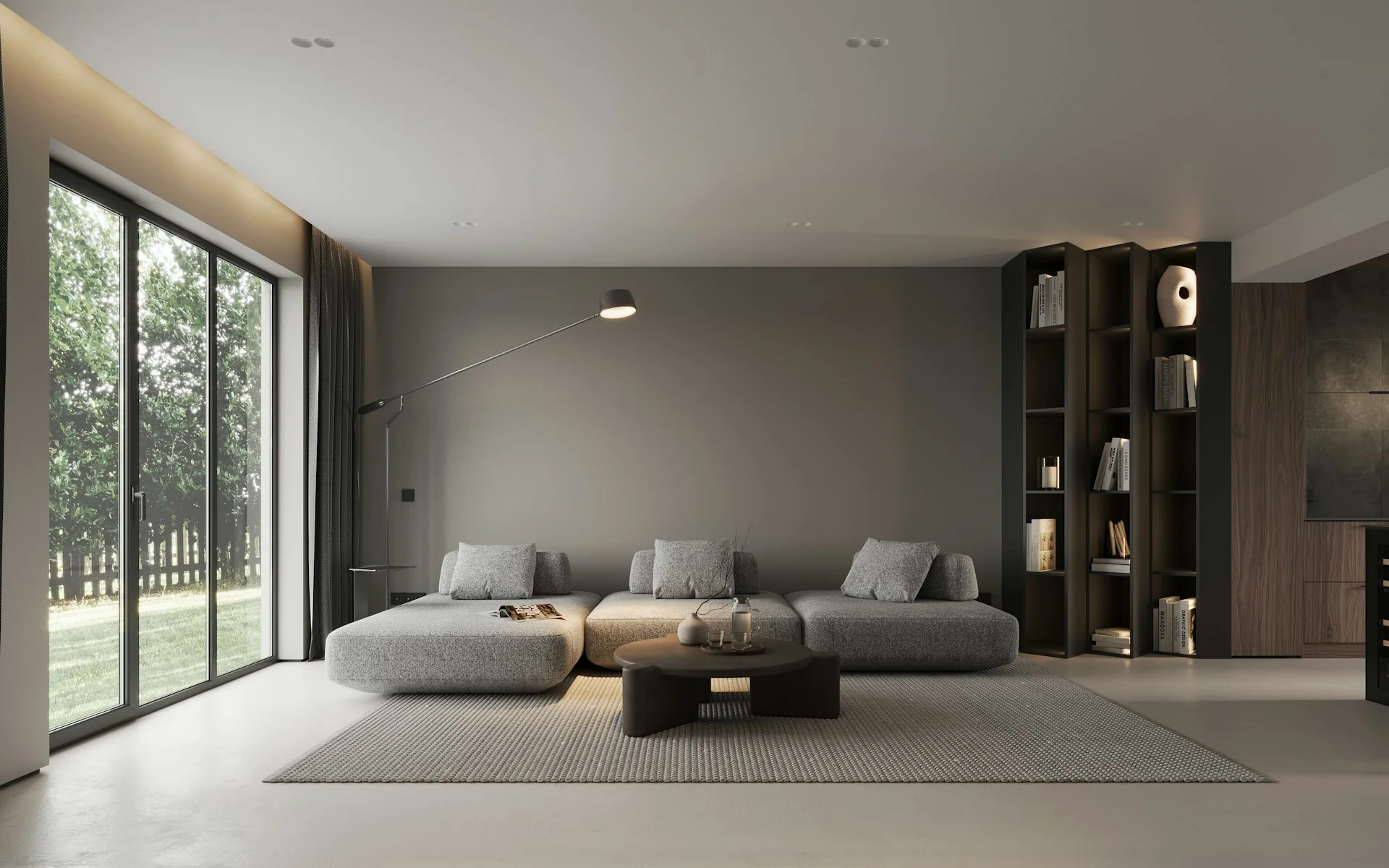 Salón moderno de diseño minimalista con suelo continuo de microcemento claro, sofá modular gris y gran ventanal al jardín.